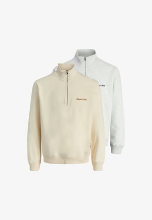 Två zip-up sweatshirts: en krämfärgad med hög krage och broderad logotyp, och en grå med en liknande design och ribbade ärmslut.