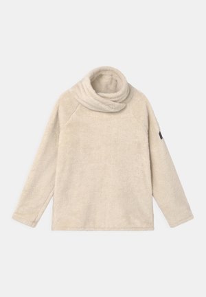Pull-over en polaire crème avec un col haut roulé et des manches longues. Présente une texture lisse et un petit logo noir sur la manche.