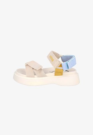 Sandalia de plataforma beige con tiras anchas, correa azul claro en el tobillo con velcro, acento amarillo cerca del talón y suela acolchada.