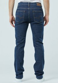 Donkerblauwe denim jeans met een rechte snit, voorzien van een leren achterpatch en twee aparte achterzakken met contrasterende stiksel.