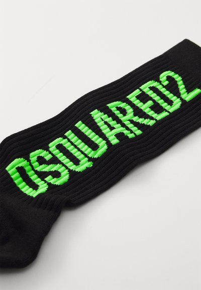 Čierne rebrované ponožky s výrazným zeleným textom "DSQUARED2" tkaným na prednej strane. Dizajn je textúrovaný s hladkým povrchom.