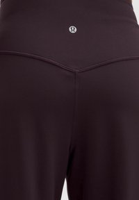 Bordeaux-housut korkealla vyötäröllä, valmistettu sileästä, venyvästä kankaasta, jossa on hieno kiilto. Sisältää litteät saumat ja pienen logon vyötärönauhan kohdalla.