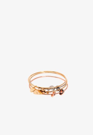 Conjunto de pulseras apiladas en tonos de oro y oro rosa, de diferentes grosores, con charms en forma de corazón y circular. Textura suave.