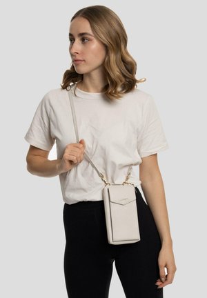 Lichtbeige schoudertas van textuurmateriaal, met een klep bovenaan, gouden accenten en een verstelbare schouderband.