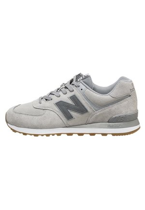 Chaussure de sport en suède gris avec un logo gris foncé, une semelle intermédiaire blanche et une semelle en caoutchouc. Comprend une languette rembourrée et un design à lacets.