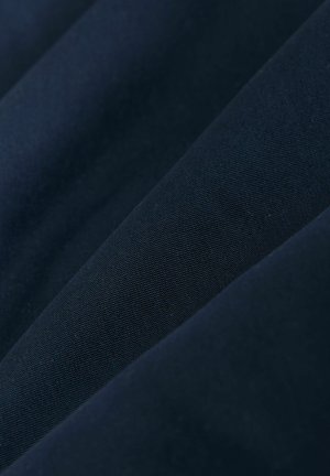 Laivastonsininen kangas, jossa on sileä tekstuuri, hienovarainen kudoskuvio ja mattapintainen viimeistely. Materiaali on kevyt ja joustava.