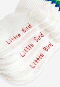 Hvide bomuldsstrømper med røde "Little Bird"-tekst. Blød tekstur med ribbede mansjetter og en glat krop. Flere par stakket.