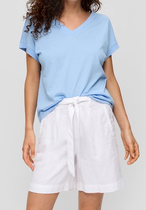 Lyseblå kortærmet v-hals t-shirt kombineret med hvide linnedshorts med bindebånd i taljen. Enkel og afslappet design med rene linjer.