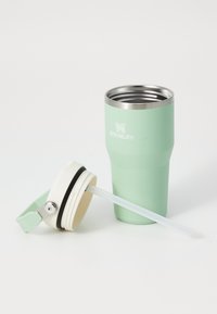 Tumbler isolé Stanley vert menthe avec un bord en acier inoxydable et un couvercle blanc détachable avec une paille.