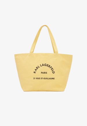 Yellow tote bag with double handles featuring "KARL LAGERFELD PARIS 21 RUE ST-GUILLAUME" printed in black on front.