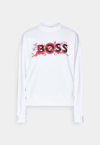 Sweat-shirt blanc à manches longues avec texte noir « BOSS » superposé sur des illustrations de dragons rouges sur la poitrine.