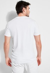 Valge puuvillane T-särk, ümar kaelus, lühikesed varrukad ja figuuri järgiv lõige, millel on sile ja pehme tekstuur ning nähtavad logod või graafika puuduvad.