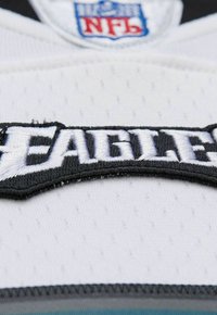 Weißes Sporttrikot aus Stoff mit schwarzem, gesticktem "FEARLESS"-Patch. Verfügt über das NFL-Logo, eine strukturierte Oberfläche und genähte Akzente.