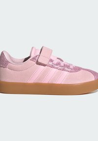 Pink suede sneaker with glittery accents, three side stripes, hook-and-loop strap, laces, and gum rubber sole.