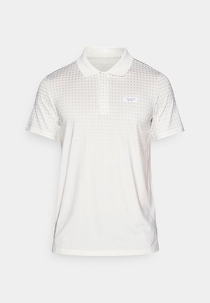 Λευκό πόλο μπλουζάκι από ελαφρύ ύφασμα, με διακριτό πουά σχέδιο και κλασικό γιακά. Περιλαμβάνει μια μικρή ετικέτα με το λογότυπο.