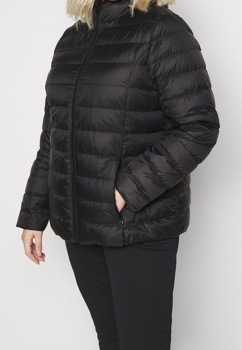 Giacca piumino nera con cuciture orizzontali, colletto alto e zip frontale. Dotata di tasche laterali e texture liscia e lucida.