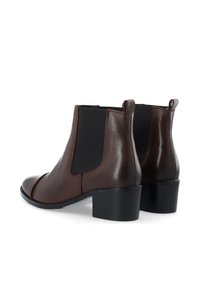 Pruunid nahast pahkluu saapad elastsete külgpanelidega, ümmargune varvas ja madal plokkkonts, omades siledat tekstuuri ja minimalistlikku disaini.