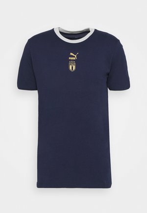 Granatowy t-shirt Puma Italia z krótkim rękawem, białym kołnierzykiem oraz złotym logo Puma i herbem Włoch na piersi.