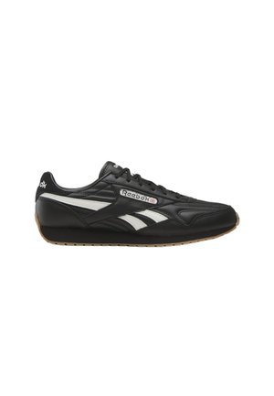 Zapatilla negra de Reebok con rayas blancas, cordones negros y suela de goma, mostrando vista lateral con logo y detalles de costuras.