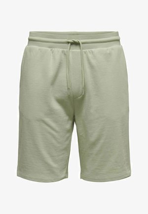 Shorts en coton vert clair avec une taille élastique, un cordon de serrage et une coupe décontractée. Présentent une texture lisse et des bords ourlés.