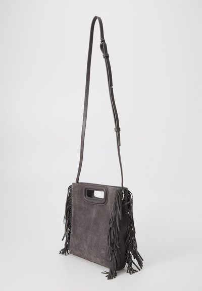 Geantă de umăr din suede gri, cu accente de franjuri. Are un mâner superior și o curea reglabilă. Textură netedă și formă rectangulară.