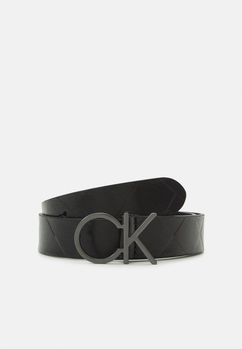 Cintura in pelle nera con motivo a diamante, dotata di una fibbia in metallo nero opaco impressa con "CK". Il design è sottile ed elegante.