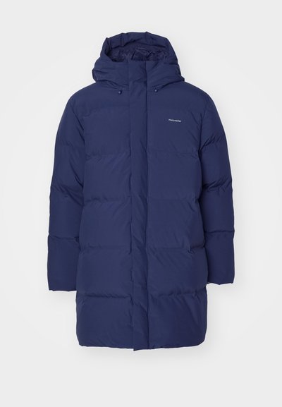 Jūras spēku tumši zila pūkaina jaka ar kapuci, ar rāvējslēdzēju un quilted tekstūru. Zīmols redzams augšējā kreisajā krūtī.