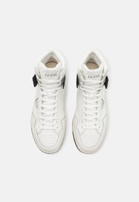 Sneaker alte in pelle bianca con dettagli neri e logo. Presentano una punta perforata, lacci e un collo imbottito per il comfort.