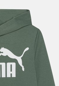 Groene sweatshirt met een capuchon, gemaakt van gestructureerde stof. Bevat een groot wit Puma-logo en tekst, wat een sportieve uitstraling geeft.