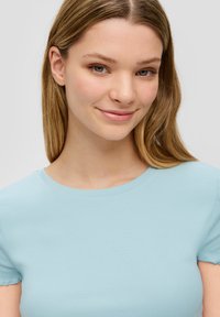 Lichtblauw geribbeld T-shirt met korte mouwen en een ronde halslijn, gemaakt van een zachte stof, met een aansluitend ontwerp en een gladde textuur.