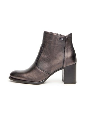 Bottine en cuir métallisé noir avec un talon carré, une pointe effilée et des détails de couture sur les côtés, comportant un petit logo sur le dessus.