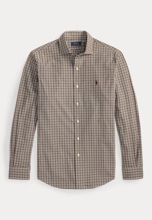 Chemise à manches longues à carreaux marron et blancs avec un col à boutons, présentant un petit logo sur la poitrine gauche et des poignets à boutons.