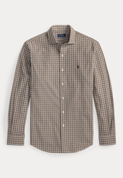 Chemise à manches longues à carreaux marron et blancs avec un col à boutons, présentant un petit logo sur la poitrine gauche et des poignets à boutons.