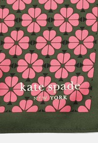 Tessuto verde con un motivo floreale ripetuto di cuori rosa, accentuato da triangoli neri. "kate spade NEW YORK" in bianco sotto il motivo.
