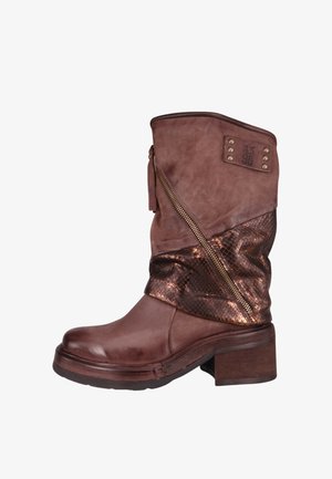 Brązowy skórzany botek za kostkę z teksturowanym brązowym akcentem, bocznym zamkiem błyskawicznym i masywnym obcasem. Ozdobiony małymi ćwiekami na górnej części.