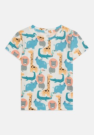 Lühikeste varrukatega puuvillane T-särk, millel on mitmevärviline looma muster, sinised elevandid, lõvid, kaelkirjakud ja krokodillid kreemival taustal.