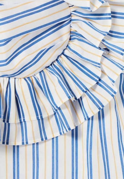Tessuto bianco con strisce blu e gialle, caratterizzato da un bordo arricciato. La texture appare liscia con una leggera lucentezza.