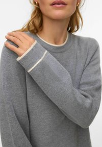 Hall halli kampsun pehme tekstuuriga pinnaga. Omab ümarat kaelusjoont ja kontrastseid koorevärvilisi aktsente varrukaotstel.