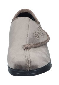 Beige suede slipper with a rounded toe, elastic lace detail, and stitched accents. Black rubber sole for grip and durability.