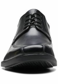 Scarpa da uomo in pelle nera con finitura liscia, punta rotonda e design con lacci. Presenta una suola in gomma testurizzata per una maggiore aderenza.