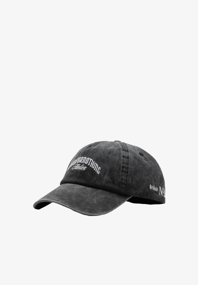 Casquette de baseball noire en coton avec une visière courbée. Présente des logos brodés blancs à l'avant et sur le côté. Tissu texturé avec un aspect usé.