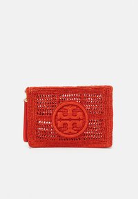 Czerwony pleciony kopertówka z okrągłą naszywką z logo haftowanym na środku przedniej części oraz bocznym paskiem na rękę z złotymi elementami.