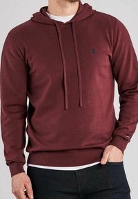 Sweat à capuche bordeaux en tissu doux. Comprend une poche kangourou, des poignets côtelés et un petit logo sur la poitrine.