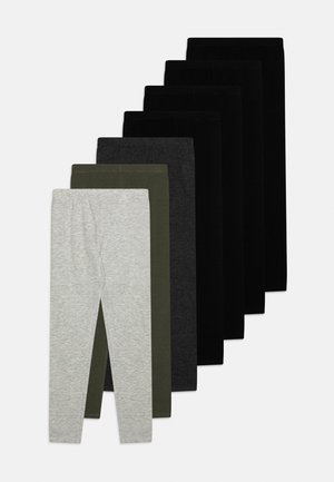 Sette paia di leggings piegati in grigio, verde, grigio scuro e quattro sfumature di nero, disposti sovrapposti su uno sfondo chiaro.