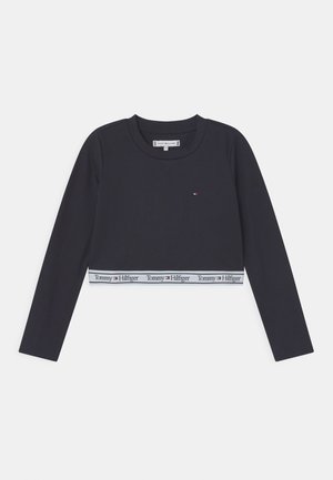 Haut court noir à manches longues avec encolure ronde, petit logo Tommy Hilfiger sur la poitrine et bande élastique de marque à l’ourlet.