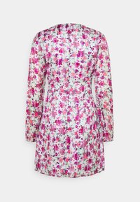 Robe blanche à manches longues, longueur genou, imprimé floral rose, violet et rouge, taille cintrée, vue de dos sur un fond uni.