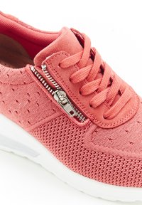 Rode mesh sneaker met een gestructureerd oppervlak, voorzien van een zijrits en vetersluiting. Witte zool biedt contrast en stabiliteit.
