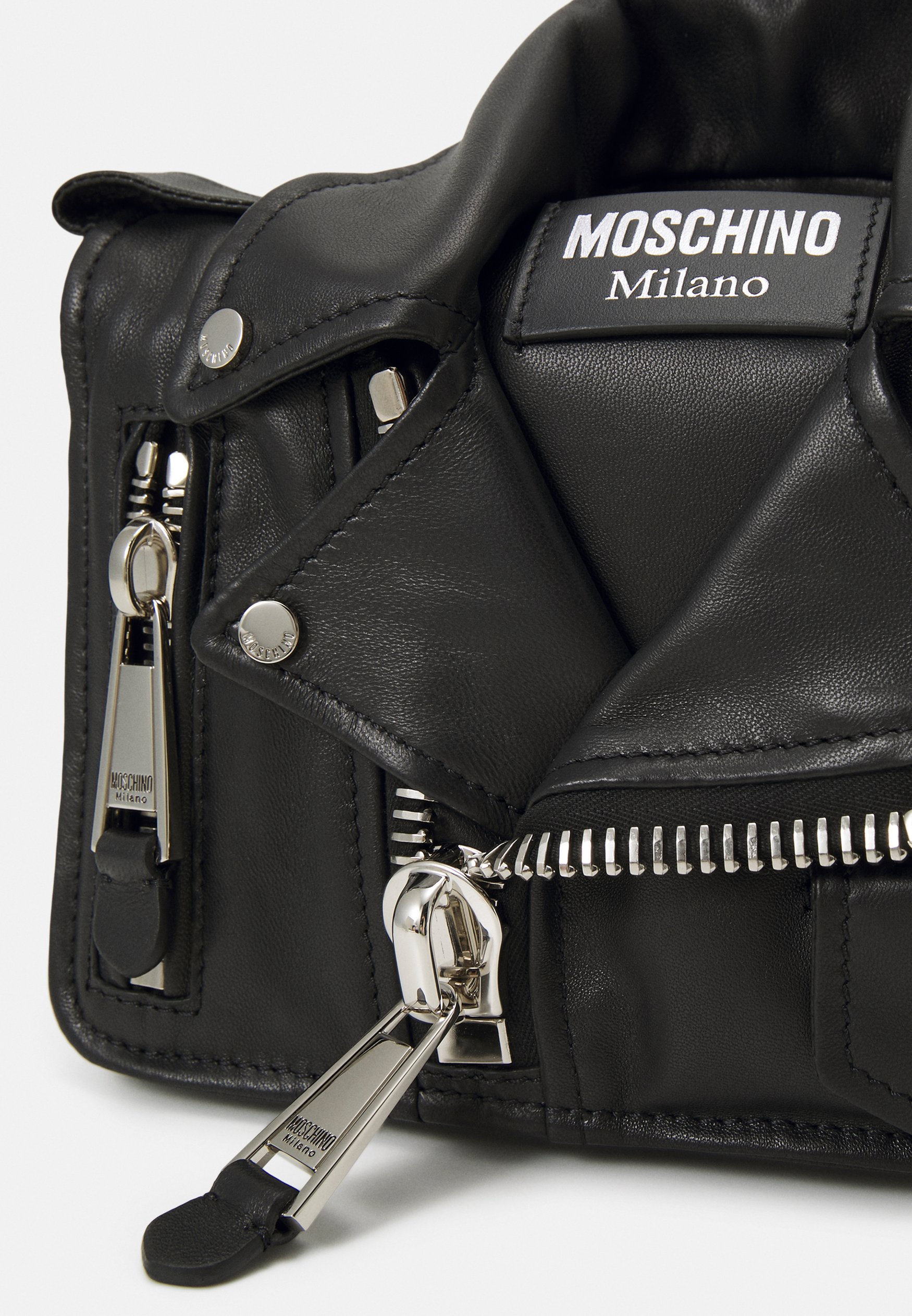 Detailed front view of a black Moschino Biker Jacket Bag with lapels, zippers and metal hardware.