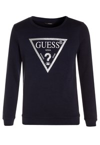 Felpa navy in tessuto morbido con colletto a girocollo, caratterizzata da un logo a triangolo argentato con "GUESS" e un punto interrogativo al centro.