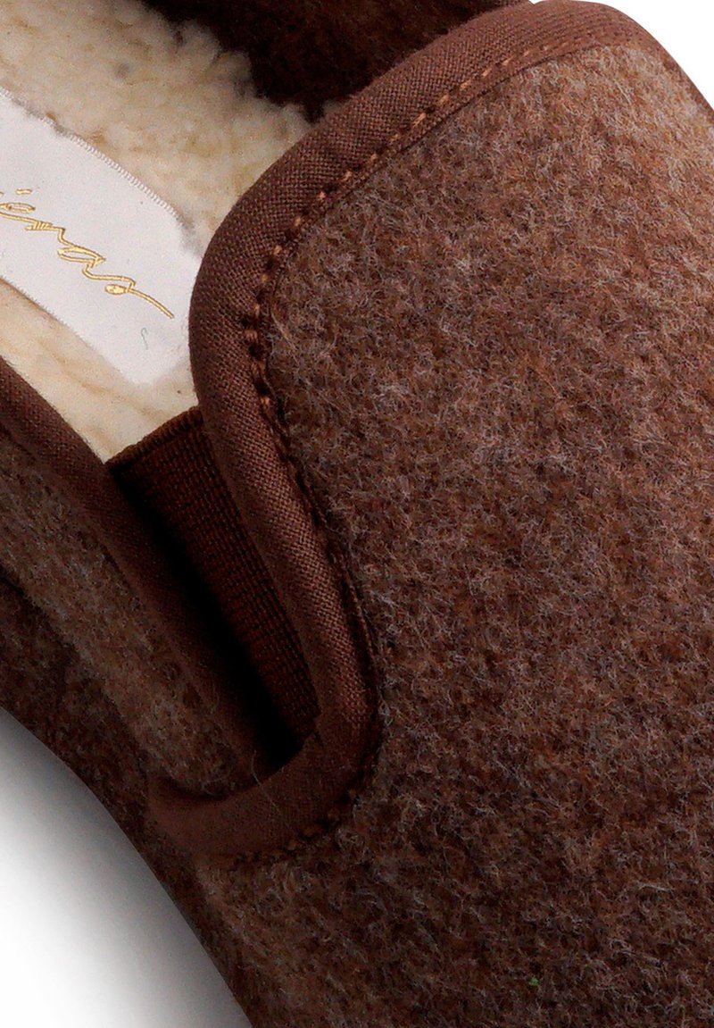 Braune Filzschuhe mit einem glatten braunen Stoffbesatz und einem weichen, strukturierten Innenfutter. Runde Form mit einem schlichten Design.